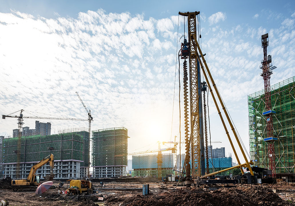 Spiral pile driver on construction site Spiral pile driver on construction site
